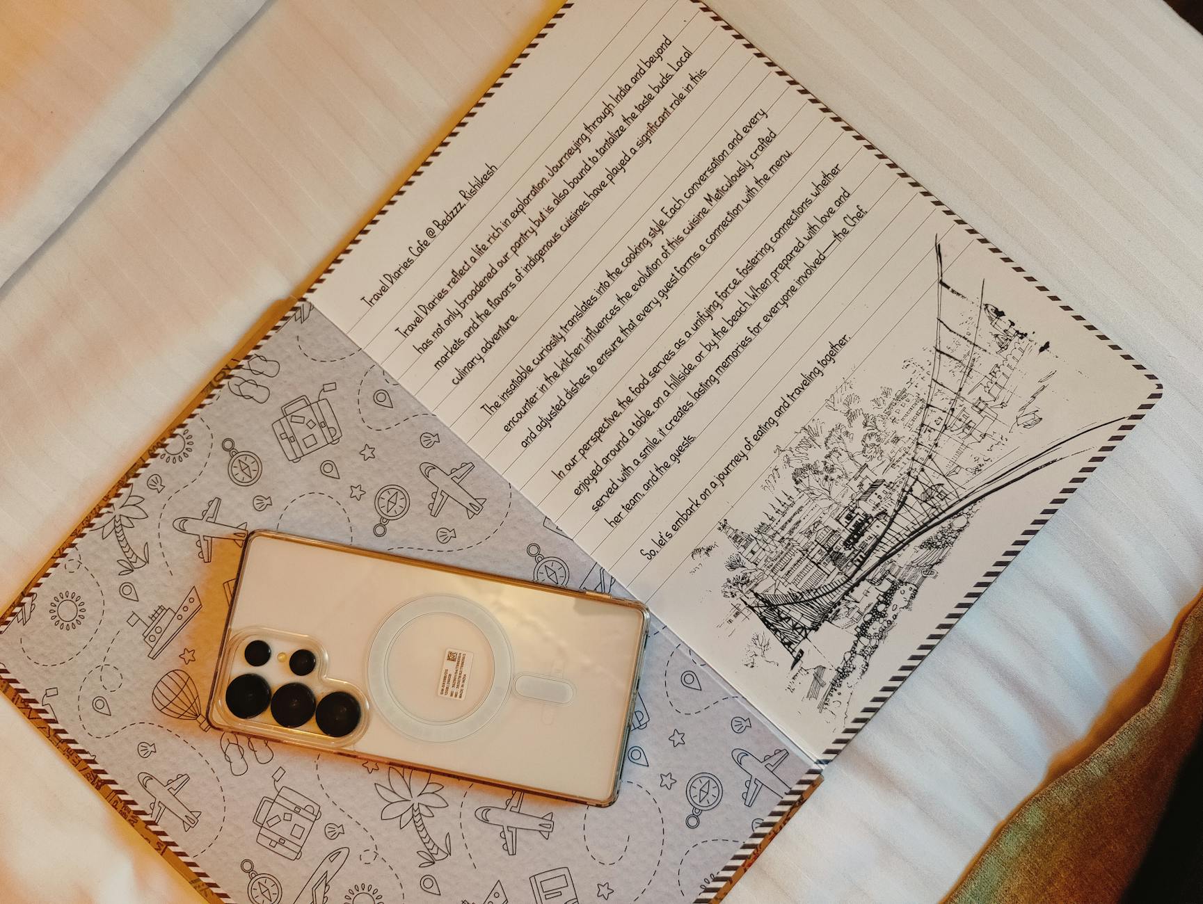 침대 위 펼친 손글씨 노트와 스마트폰, 포근한 아침 글쓰기.