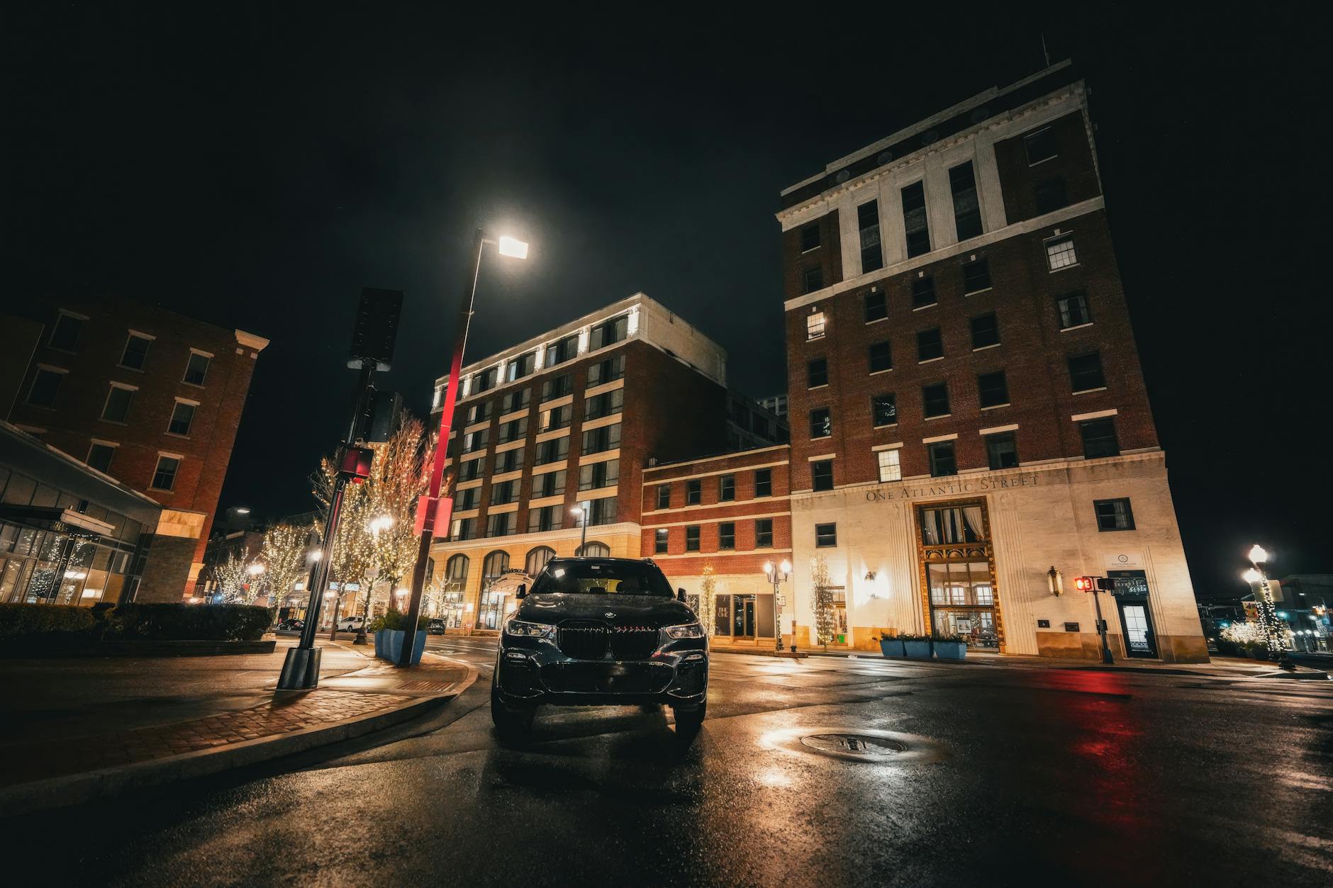 희미한 조명의 밤 도심 거리, 역사 건물 앞 주차된 고급차